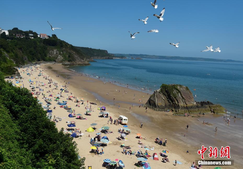 英国威尔士迎高温天气 民众前往海滩消暑